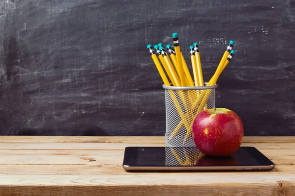 Tablet, pencils and apple