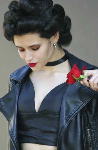 Woman in leather jacket with rose