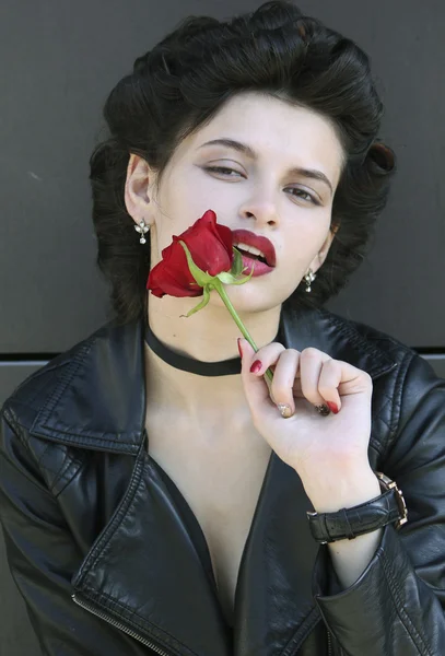 Woman in leather jacket with rose