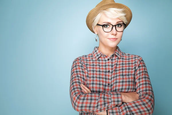 Young fashion woman with short blond hair in hat and shirt with glasses