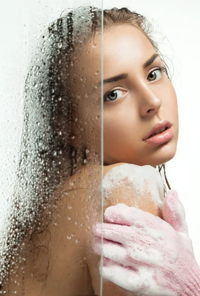 Beautiful girl washing her body shower gel for weeping glass shower door