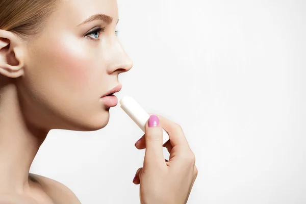 Girl healthy skin applying protective lip balm