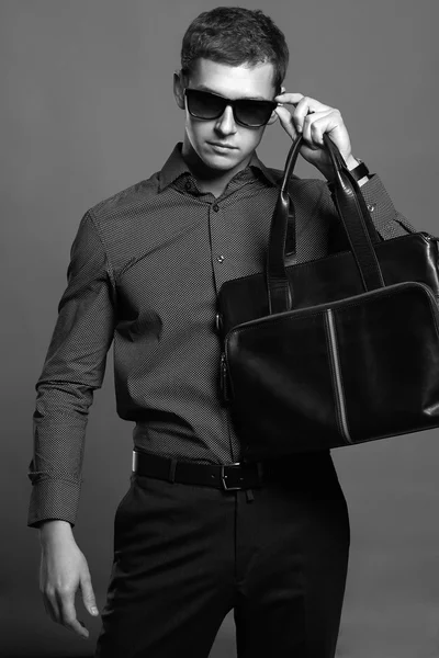 Young man with a handbag. Handsome boy in sunglasses