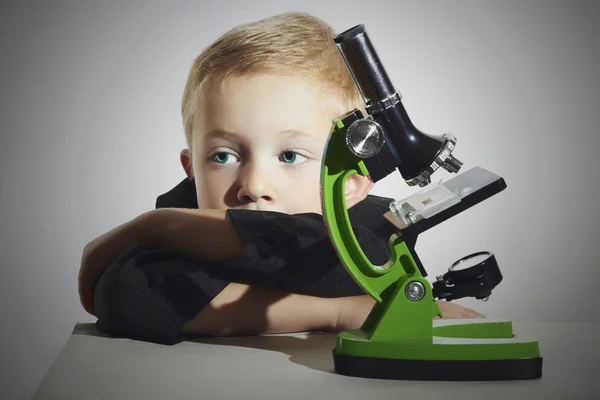 Little scientist.fashion portrait of little boy in tie.funny child.Schoolboy working with a microscope