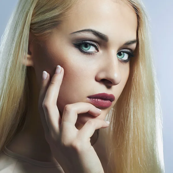 Blond woman with manicure.Beautiful girl model with blue eyes lens