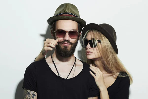 Beautiful happy couple in hat wearing trendy glasses together