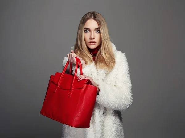 Winter beautiful Woman with red Handbag. Beauty Fashion Model Girl in fur. luxury stylish blonde