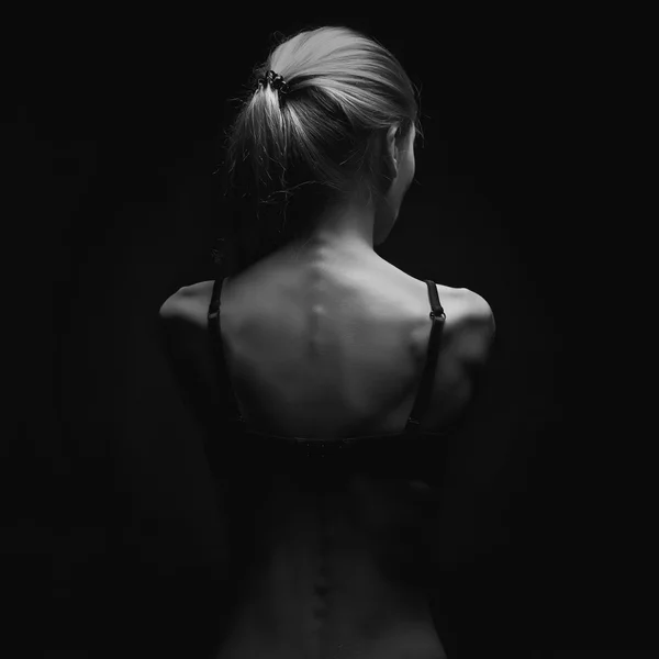 Sad woman with naked back over black background.sexy body girl