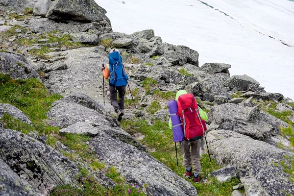 Hikers are climbing rocky slope of mountain in Altai mountains,
