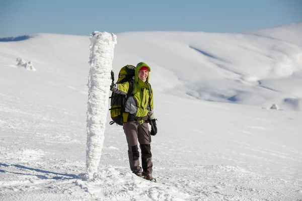 Backpacker woman posing in winter mountains