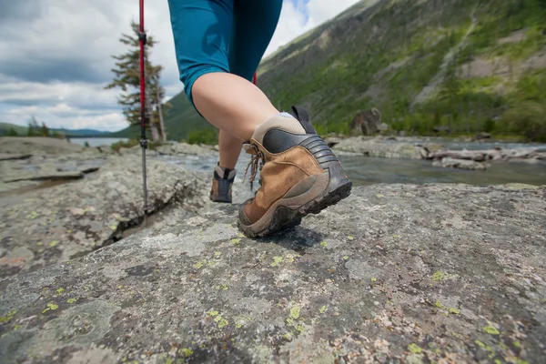 Hiking boot closeup on mountain rocks