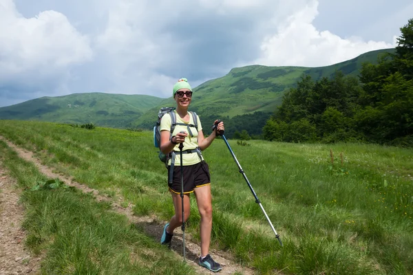 Young people are hiking in Carpathian mountains in summertime