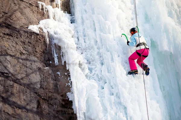 Man climbing frozen waterfall