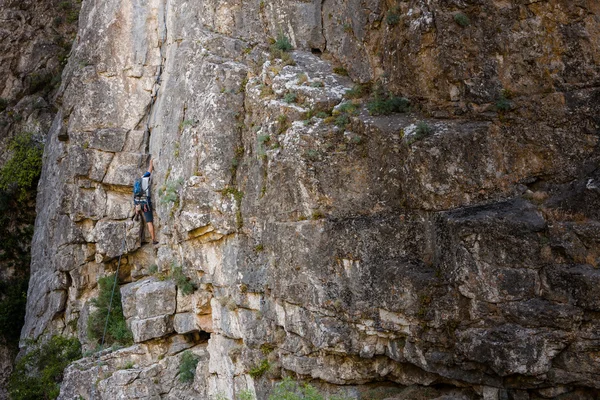 Man practices in climbing at the rock in the Crimea mountains