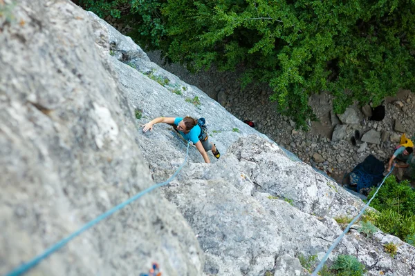 Woman practices in climbing at the rock in the Crimea mountains