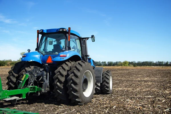 Tractor with plow working in the field