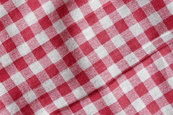 Texture of a red and white crumpled picnic blanket.