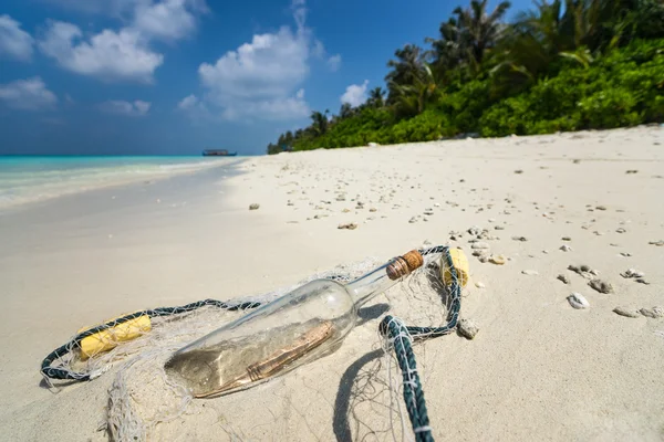 Message in a bottle washed ashore on a tropical beach.