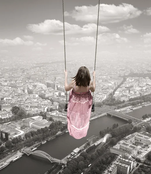 Young woman on a swing on the Paris town backround