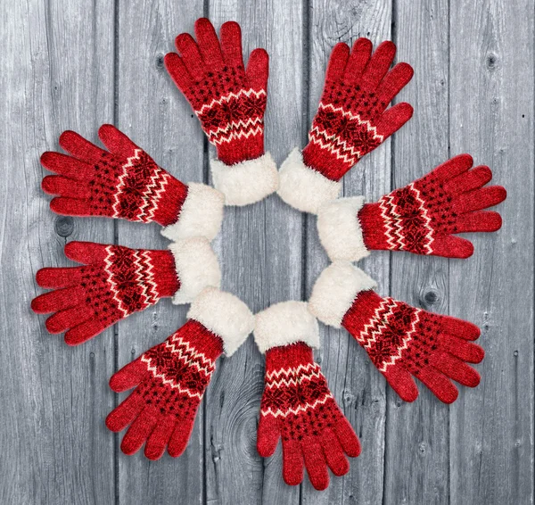 Ornament with red gloves on wooden background. Christmas, winter