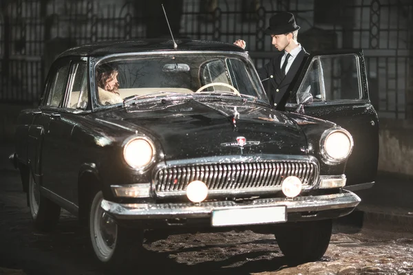 A young couple with a retro car
