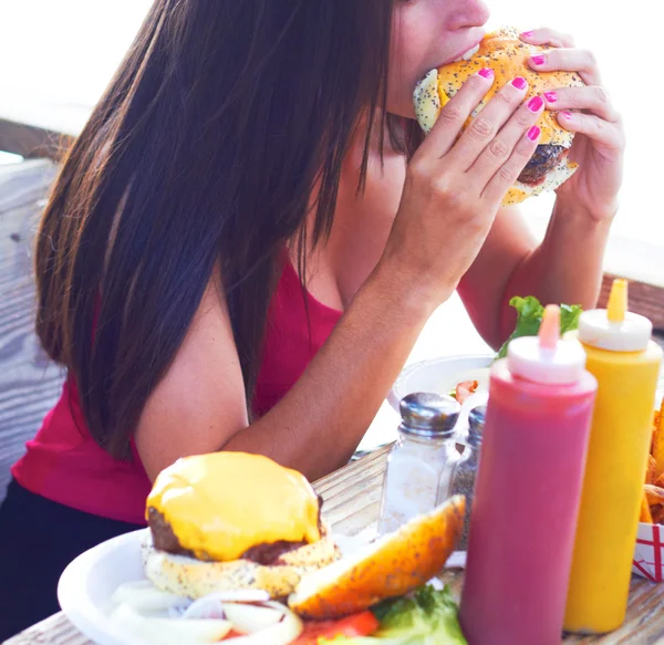 Woman Eating Cheeseburger