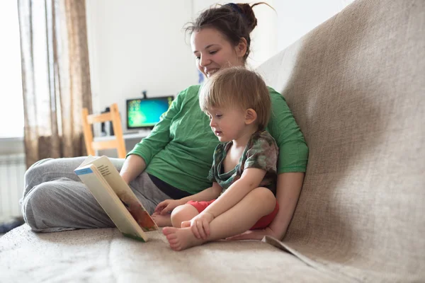 Happy family mom and son  at home kitchen together read book