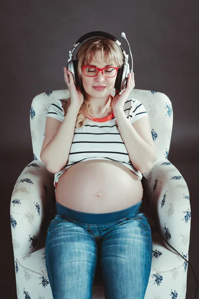 Pregnant woman listening to music on headphones