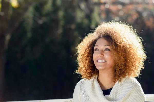 Young African American girl with afro hairstyle and green eyes