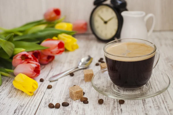 Cup of coffee and bouquet of tulips