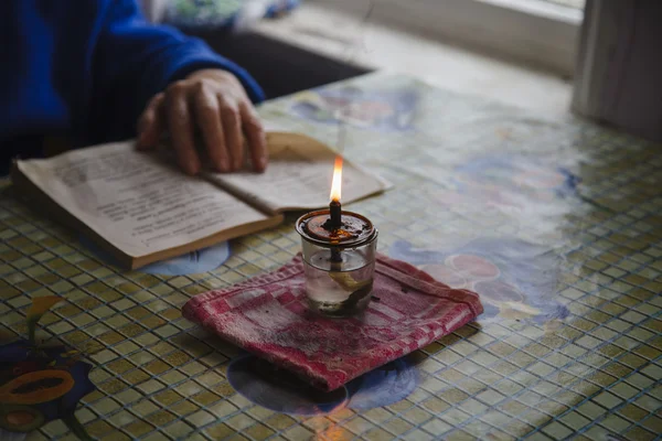 Fire of an icon lamp and the hand holding the book