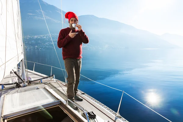 Men makes a coffee break on sailboard