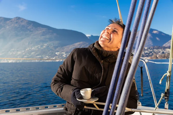 Woman makes a coffee break on the sail boat