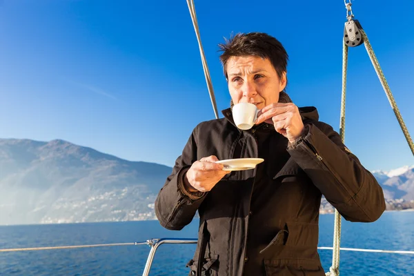 Woman makes a coffee break on the sail boat