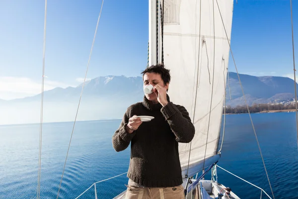 Woman makes a coffee break on the sail boat