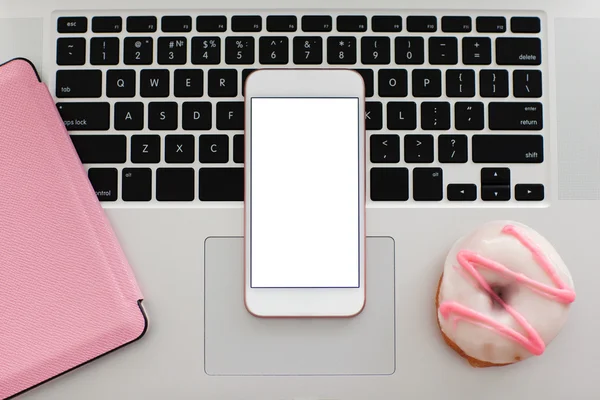 White pink phone with isolated screen on the notebook keyboard