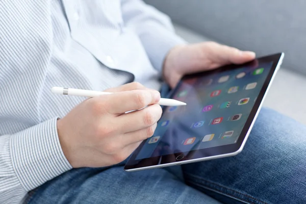 Man with Apple Pencil holding in the hand iPad Pro