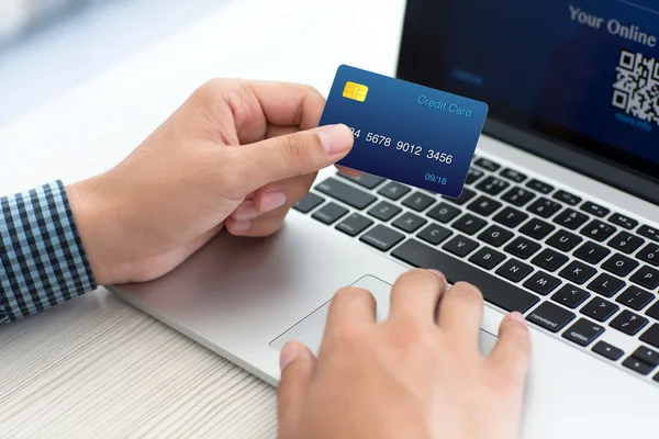 Man doing online shopping with credit card on laptop