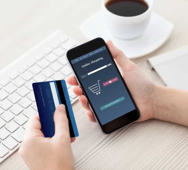 Woman holding phone with online shopping and a credit card