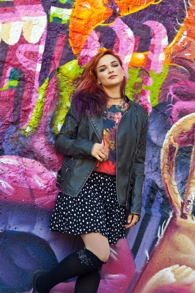 Young girl in front of graffiti