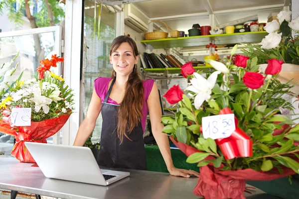 Florist woman using a laptop in her store