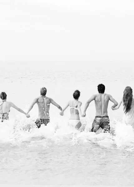 Friends running into the sea water together