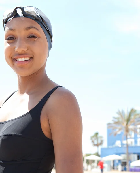 Young woman swimmer standing on a beach