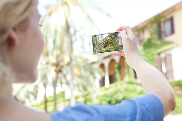 Girl take pictures of a monument on a smartphone