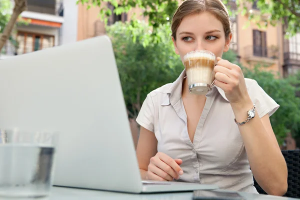 Business woman at a cafe using a laptop computer