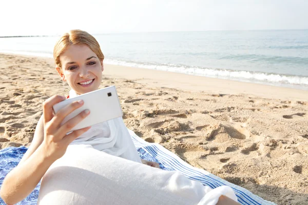 Woman using smartphone on the beach
