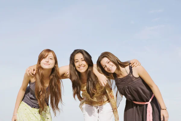 Group of three girls friends smiling to the camera