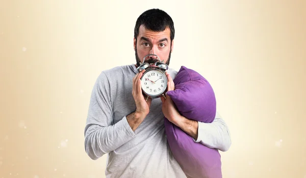 Man in pajamas holding vintage clock