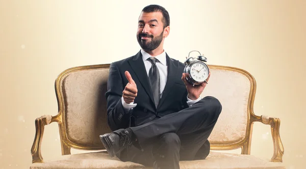 Businessman holding vintage clock