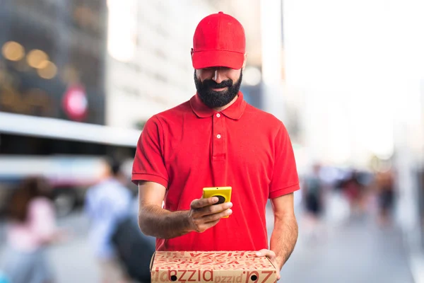 Pizza delivery man holding a mobile